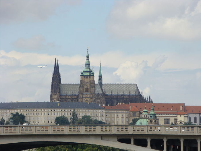 St vitus cathedral in prague against cloudy sky above the bridge