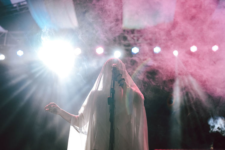 Midsection of woman holding illuminated lights at night