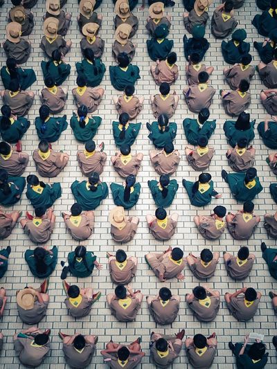 High angle view of students sitting on street