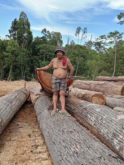 Full length of old man sitting on wood