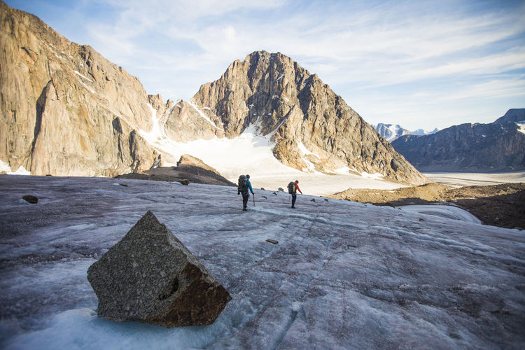 Rear view of two mountaineers crossing a mountain glacier.