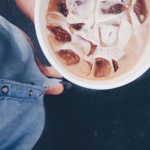Low section of woman holding iced coffee
