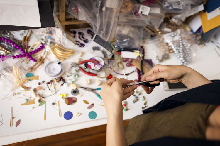 Cropped image of woman making jewelry at home