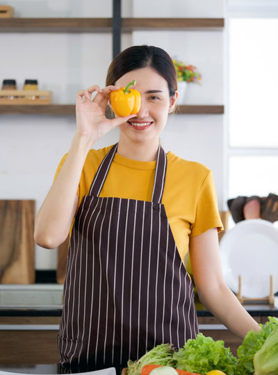 Young woman holding food while standing at home