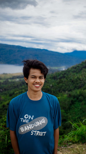 Portrait of smiling man standing on landscape