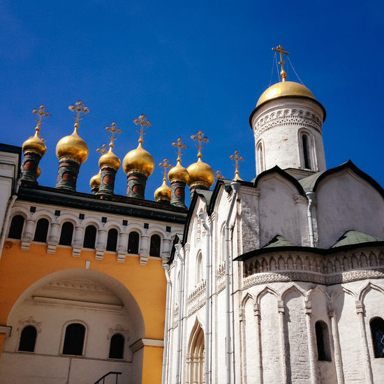 Golden domes of terem churches against clear blue sky