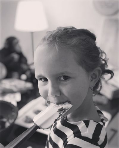 Close-up portrait of girl eating food at home