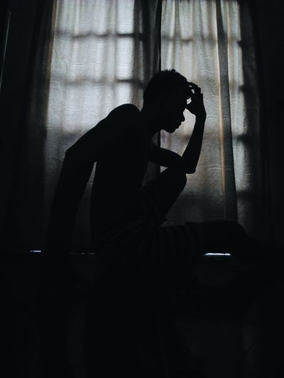 Silhouette of woman sitting at home