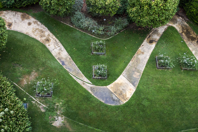 High angle view of footpath amidst grassy field in park