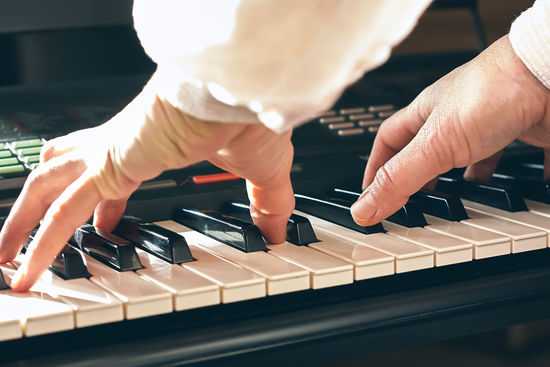 Female musician playing the digital piano or electronic keyboard at home. music education online