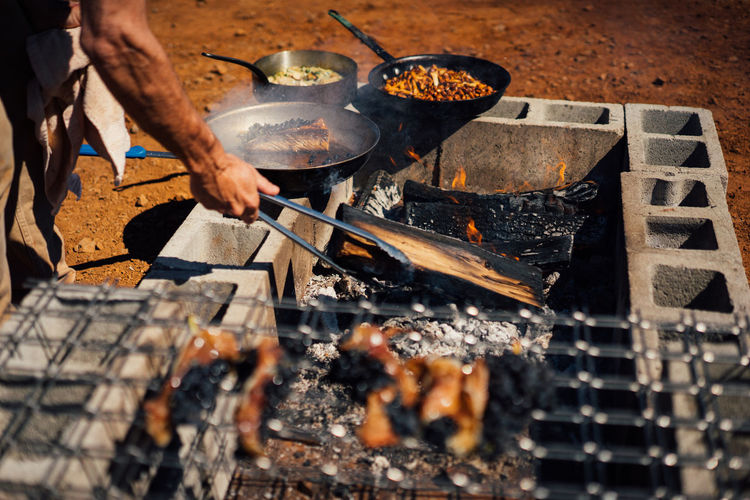 High angle view of man preparing meat on barbecue grill