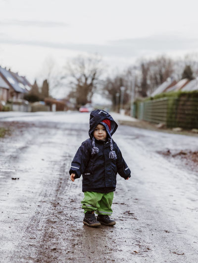 Full length of cute baby standing on wet road