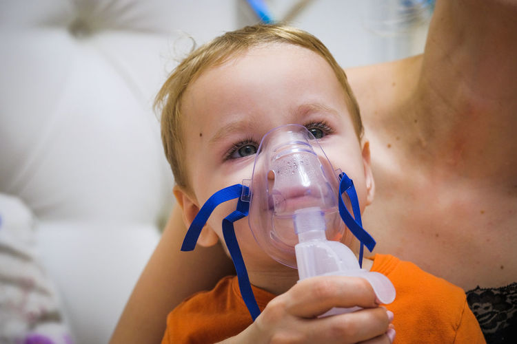 Close-up of baby wearing asthma inhaler
