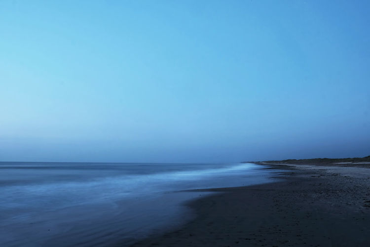 Scenic view of sea against clear blue sky