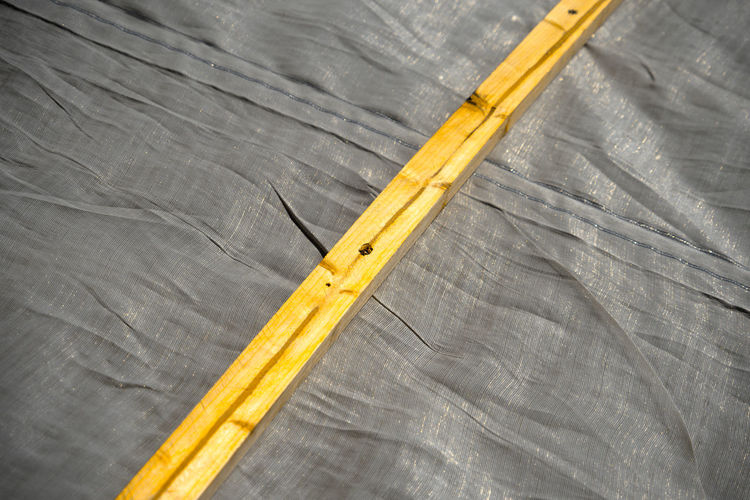 High angle view of wooden plank on gray textile