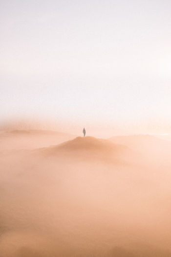 Man standing on desert against clear sky