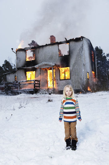 Alone girl standing in front of burning house
