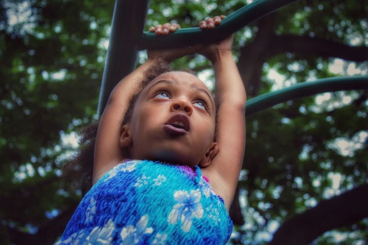 Low angle view of girl on play equipment