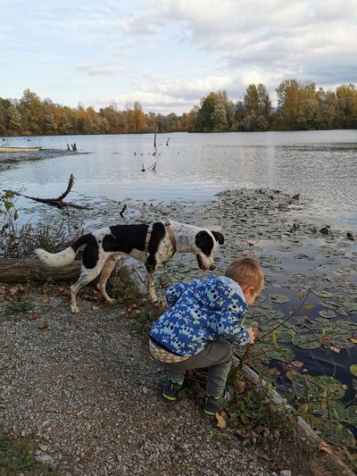 Boy and dog looking at lake