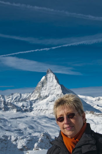 Portrait of mature woman against snowcapped mountain