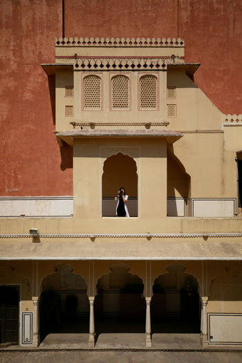 Woman photographing while standing at historic building