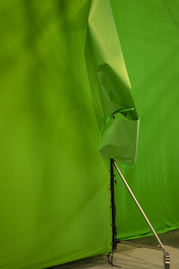 Close-up of green tied up on wall