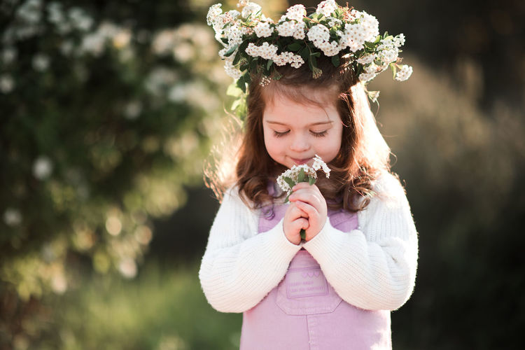 Cute girl smelling flowers in garden