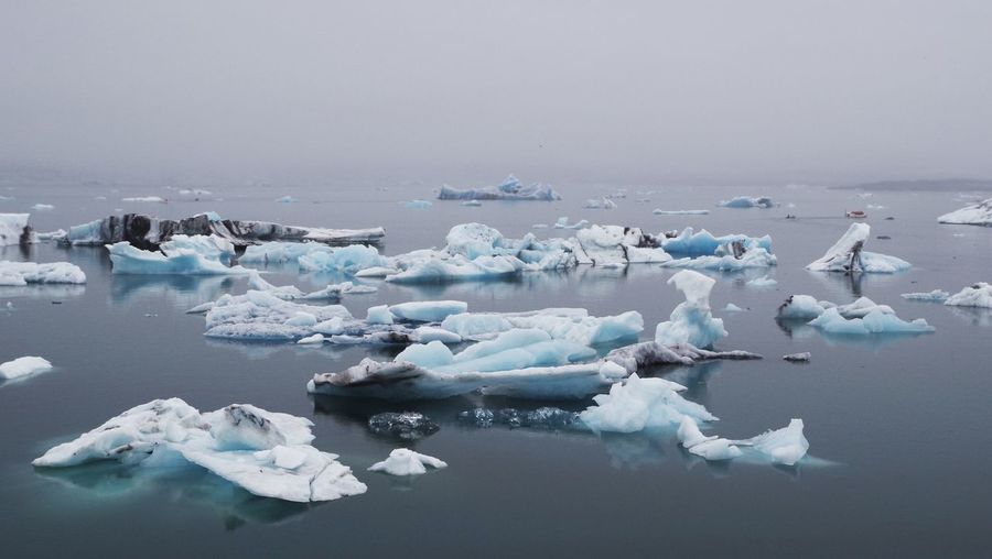 Scenic view of jokulsarlon with iceberg against cloudy sky