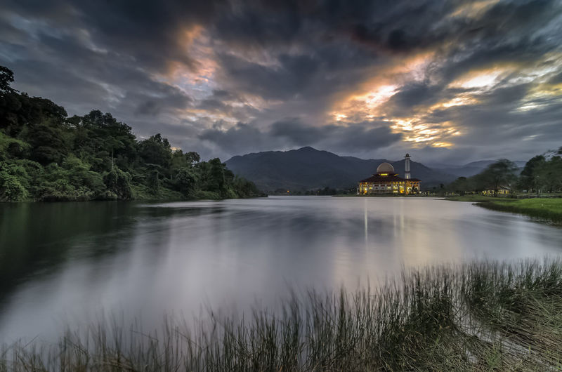 Darul quran mosque and lake against dramatic cloudy sky during sunrise