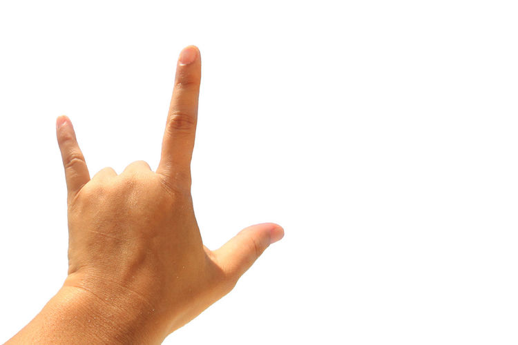 Cropped hand of person gesturing against white background
