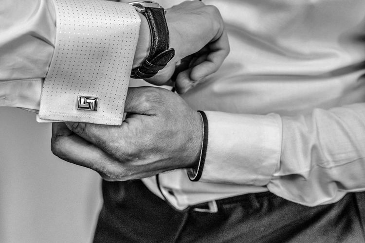 Midsection of man adjusting cuffs