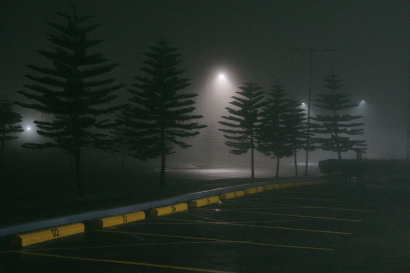 Empty road by illuminated street light against sky at night