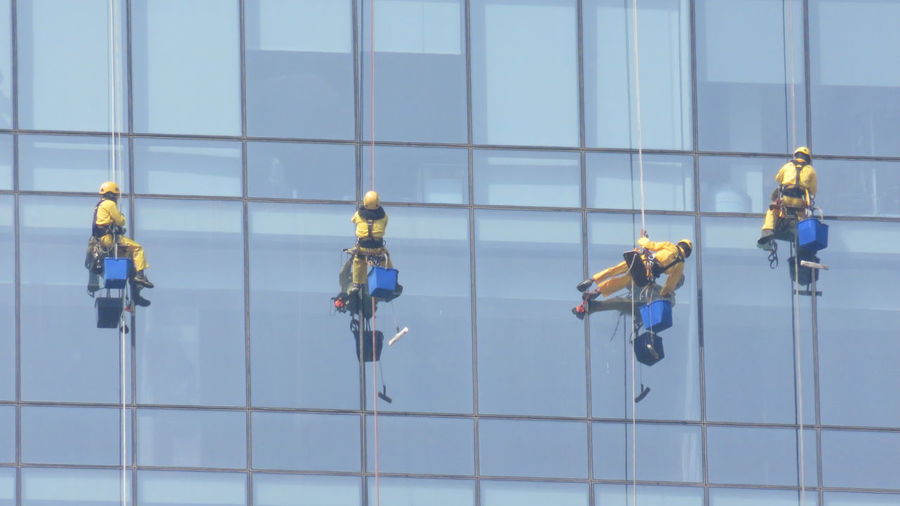 Low angle view of window washers cleaning office building