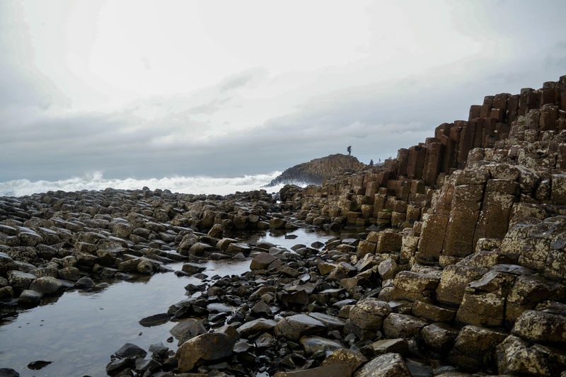 Basalt rock formation at giant causeway against sky