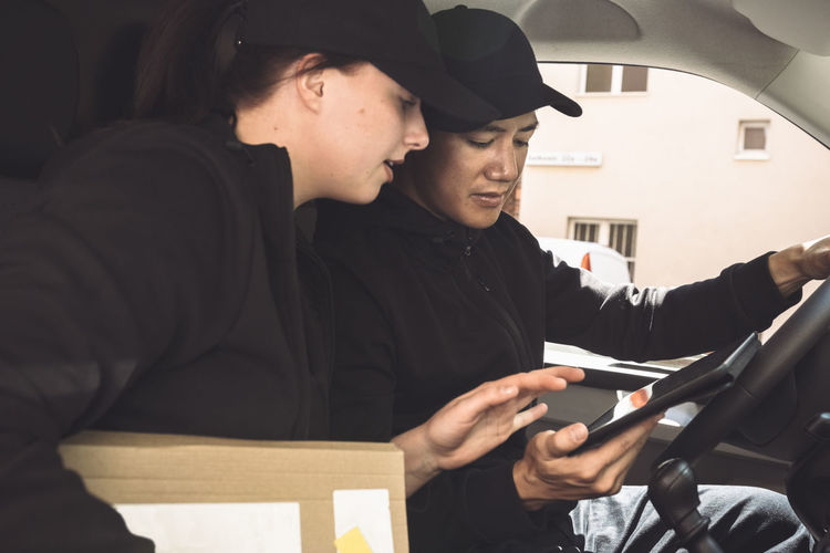 Male and female drivers using digital tablet in truck