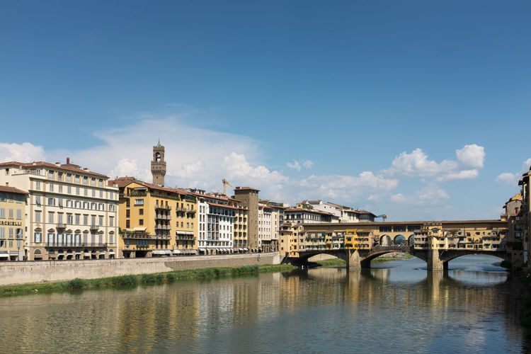 Ponte vecchio over arno river in city against sky