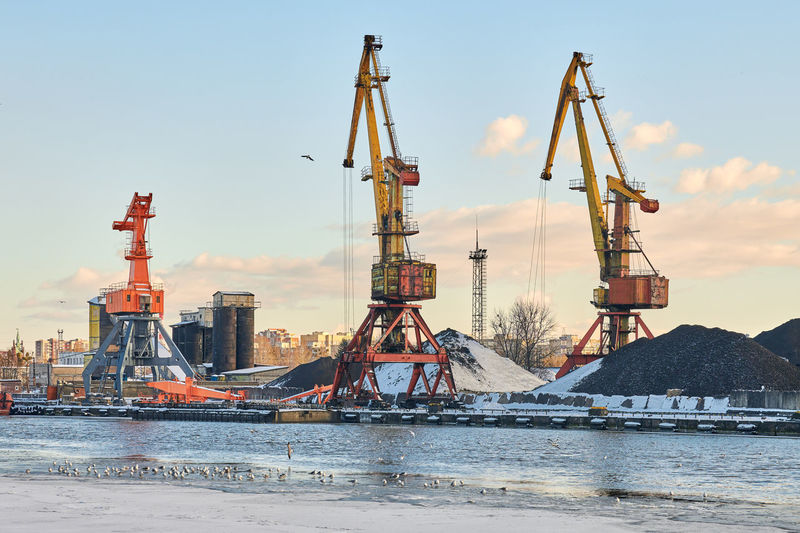 Massive harbor cranes in seaport. cranes in port, cargo container yard, container ship terminal