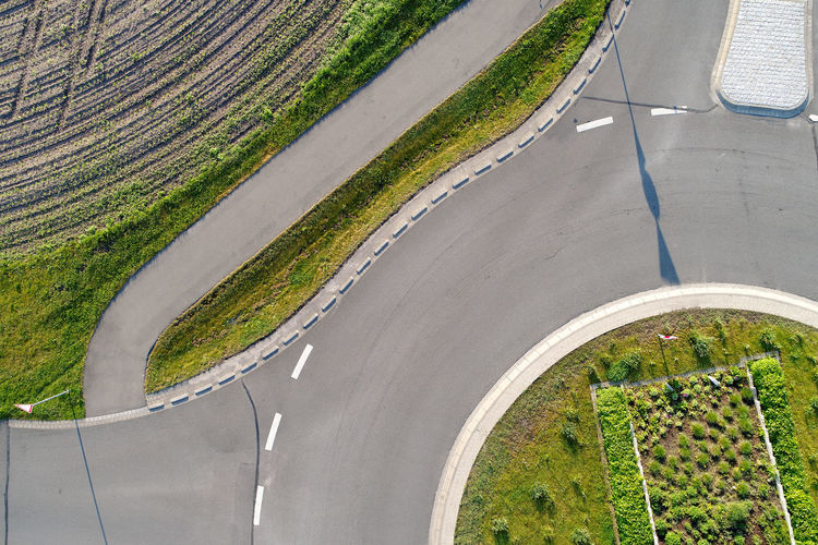 Abstract vertical aerial view of a cut roundabout next to an area of arable land