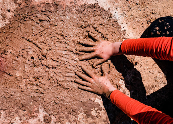 High angle view of human hand in mud