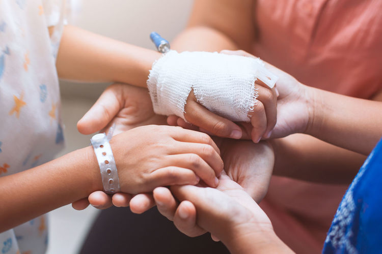 Midsection of friends consoling patient