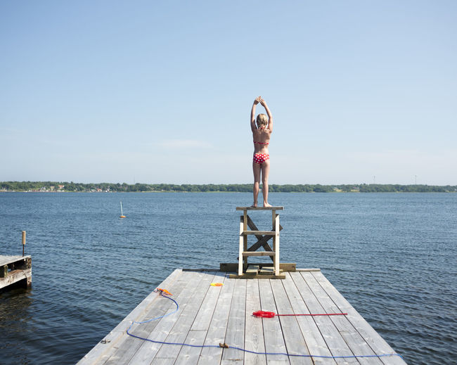 A girl diving from a jetty