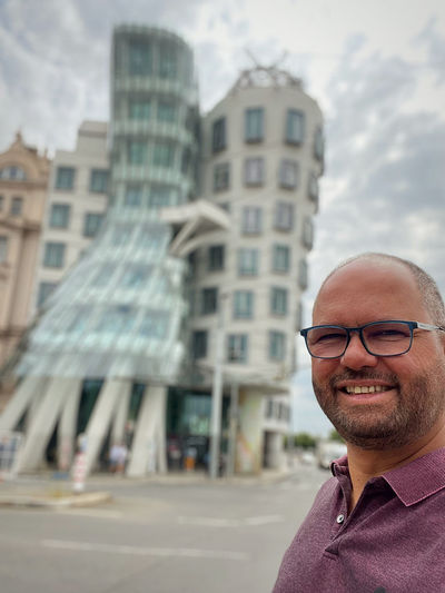 Portrait of smiling man against building in city
