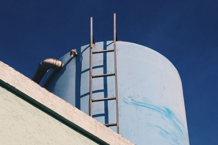 Low angle view of water storage tank against blue sky