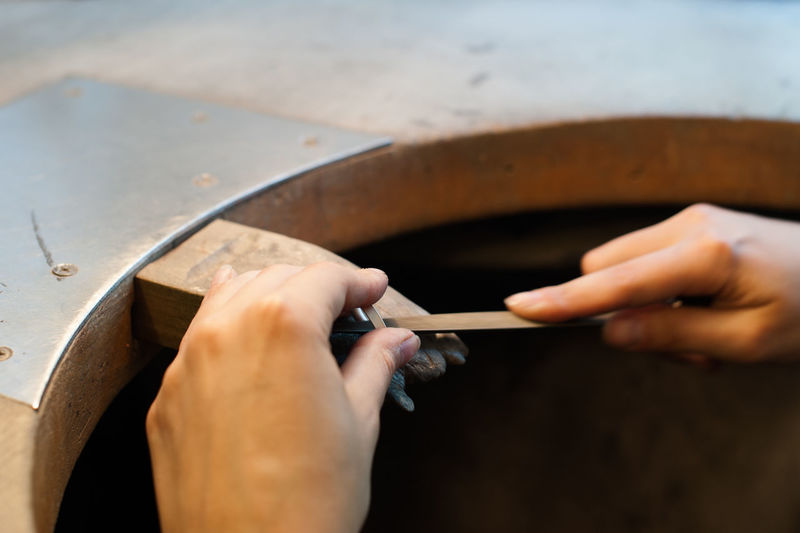 Cropped hands making wedding ring in workshop