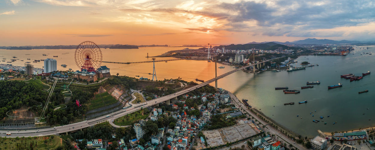 High angle view of cityscape by bay at sunset