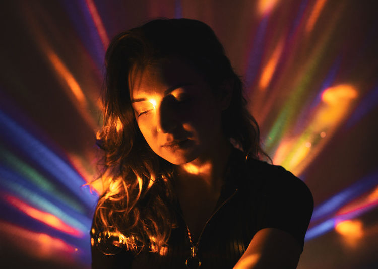 Thoughtful woman in illuminated nightclub