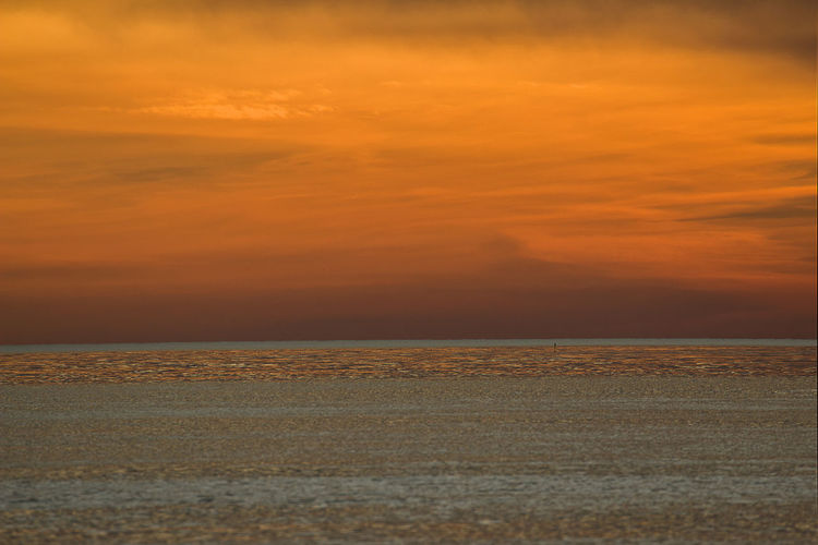 Scenic view of sea against romantic sky at sunset