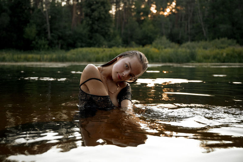portrait of young woman standing in water