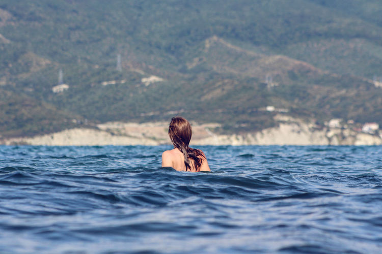 Rear view of young woman in sea