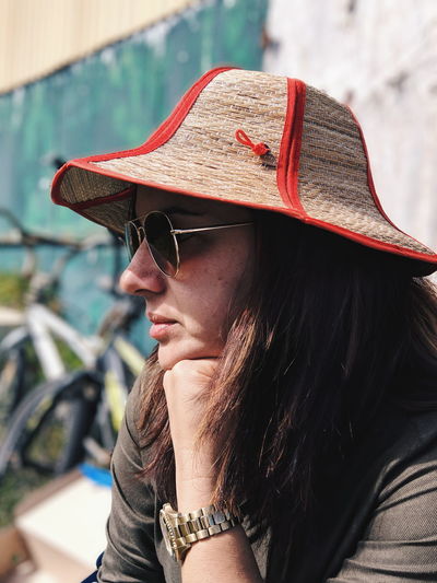 Close-up of woman wearing hat and sunglasses